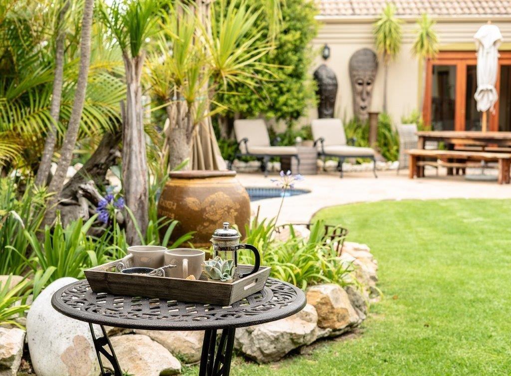 Picture of the outside of Villachad featuring grass and a coffee table with 2 cups on it